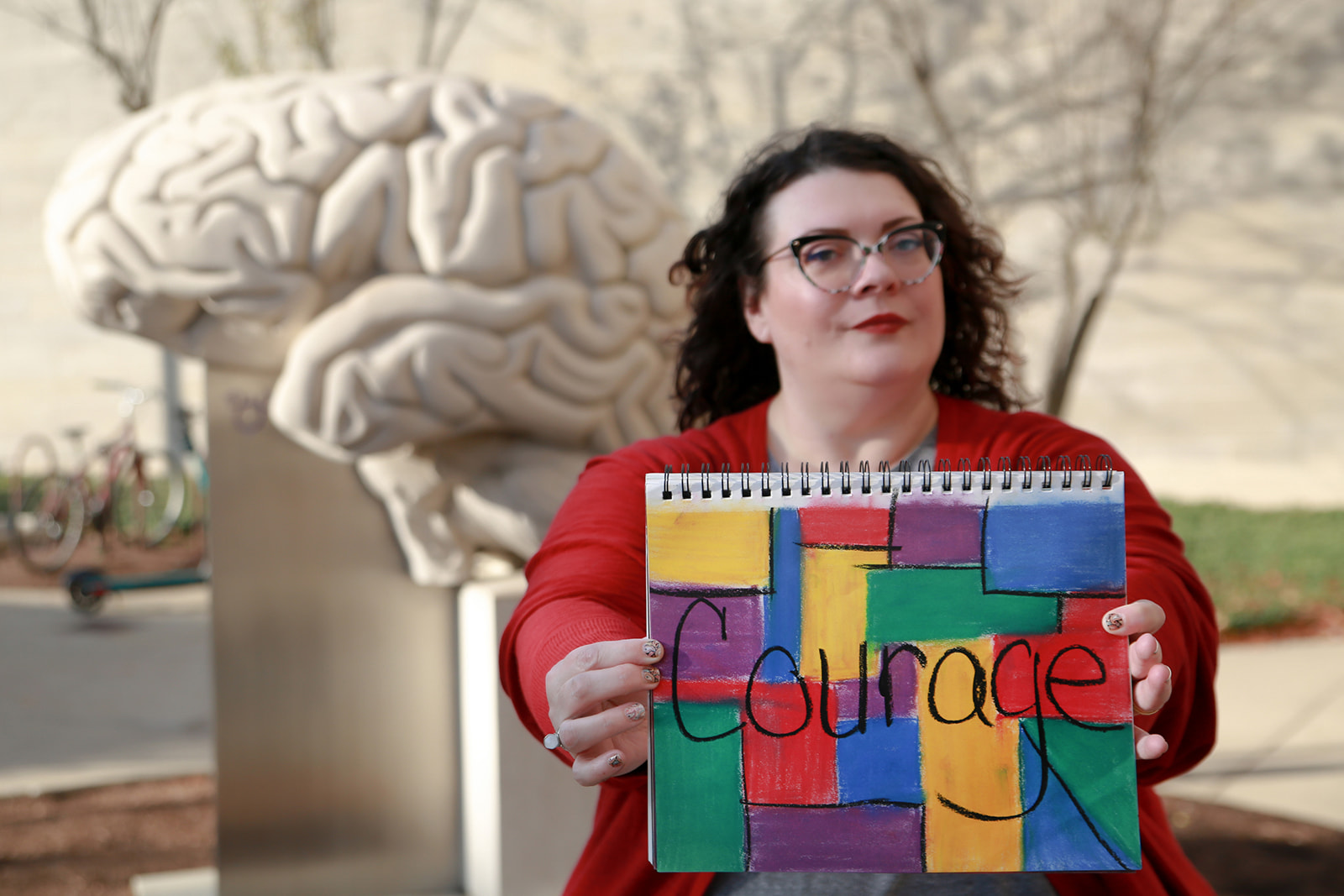 Cathleen Weber holding a sign which says Courage